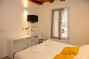 a bedroom with a bed and a desk and a window at Dimora del Borgo in Lovere