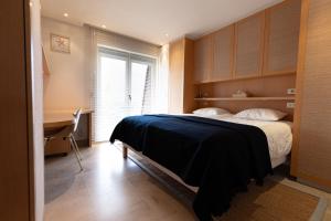 a bedroom with a bed with a desk and a window at Villa Castelli 52 Groenendijk in Nieuwpoort
