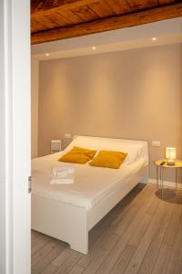 a bedroom with a white bed with yellow pillows at Dimora del Borgo in Lovere