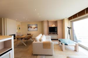 a living room with a couch and a table at Villa Castelli 52 Groenendijk in Nieuwpoort