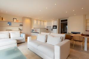 a living room with two white couches and a table at Villa Castelli 52 Groenendijk in Nieuwpoort