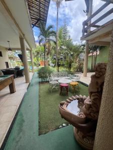 a patio with a table and a bowl of water at Casa de Temporada in Caucaia