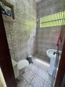a bathroom with a toilet and a sink at Casa de Temporada in Caucaia +7 photos