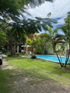 a resort with a swimming pool and palm trees at Casa de Temporada in Caucaia