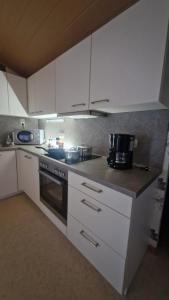 a kitchen with white cabinets and a stove at Martina in Saint-Vith +14 photos
