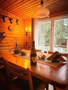 a bottle of wine sitting on a wooden table in a room at The Hunters Hill - Cosy private forest retreat in Brålanda