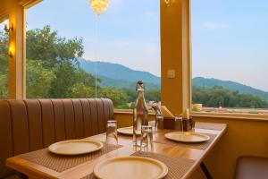 a table with plates and a bottle on it with a window at Hotel Nirvana Palace Near Parmarth Niketan in Rishīkesh
