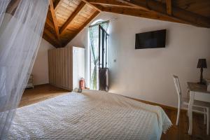 a bedroom with a white bed and a window at Manoli's Light Stone House in Vathi