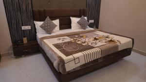 a bedroom with a large bed with at Hotel Golden Aura Inn in Gwalior