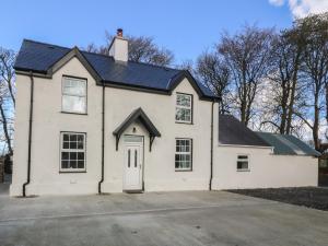 a white house with a black roof at Gate House in Llangefni