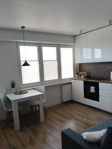 a kitchen and living room with a table and chairs at Apartament WITOSA in Ostrołęka +12 photos