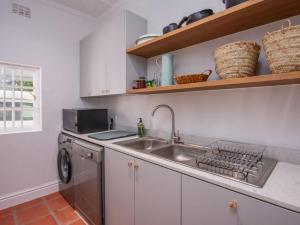 a kitchen with a sink and a washing machine at House Erens By Die Bos in Stellenbosch