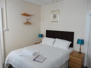 a bedroom with a bed with a book on it at Albert and Victoria Hotel in Southport