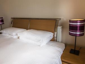 a bedroom with a bed with white sheets and two lamps at Albert and Victoria Hotel in Southport