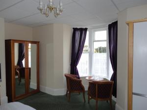 a room with a table and chairs and a window at Albert and Victoria Hotel in Southport