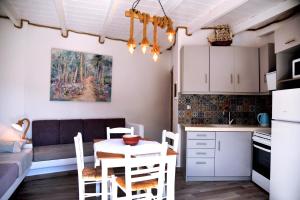 a kitchen and living room with a table and chairs at Stone Apartments Kythnos in Kanala
