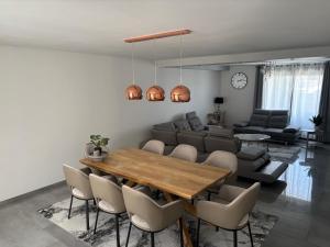a living room with a wooden table and chairs at Villa luxueuse et Moderne avec piscine ! in Béziers