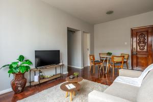 a living room with a couch and a tv at Apartamento Canto da Chaco | by Aquarela Stays in Belém
