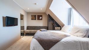 a bedroom with a large bed and a tv at Hotel Bella Ciao in Harderwijk