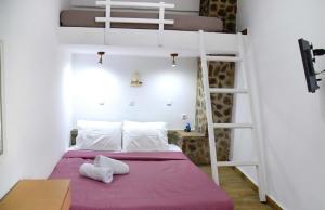 a bedroom with a bunk bed with a purple blanket at Stone Apartments Kythnos in Kanala +66 photos
