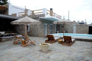 a patio with chairs and a swimming pool at Stone Apartments Kythnos in Kanala