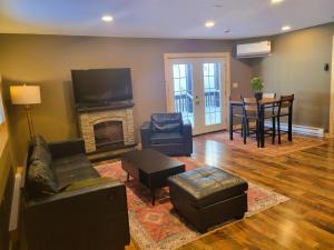 a living room with couches and a fireplace and a table at Cold Brook Lodge - 2 and 3 Bedroom Luxury Apartments in Lake Placid
