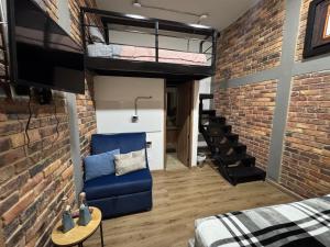 a loft conversion with a blue couch and a brick wall at Tu Hotel Chía in Chía