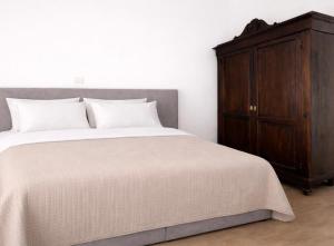 a bedroom with a bed and a wooden cabinet at Da Lorenzo Luxury Apartment in Bologna