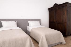 a bedroom with two beds and a wooden cabinet at Da Lorenzo Luxury Apartment in Bologna +4 photos
