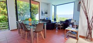 a living room with a glass table and chairs at Bean House in Vila Nova de Cerveira