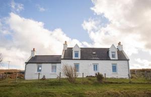 a white house on top of a field at Ben Edra Croft in Staffin