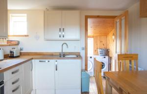 a kitchen with white cabinets and a sink at Ben Edra Croft in Staffin