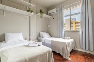 two beds in a room with a window at Apartamento Canto da Chaco | by Aquarela Stays in Belém
