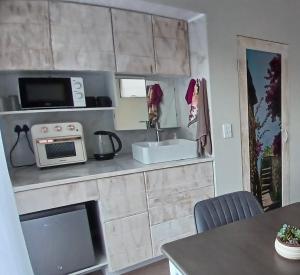 a kitchen with a sink and a microwave at Kaaimans Crest Ocean-View Studio in Great Brak River