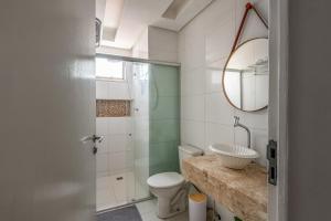 a bathroom with a sink and a toilet and a mirror at Apartamento Canto da Chaco | by Aquarela Stays in Belém +19 photos