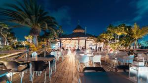 a restaurant with tables and chairs at night at BLUESEA Alyssa Suite Hotel in Playa Blanca