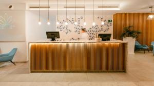 a lobby with a counter with a person behind it at BLUESEA Alyssa Suite Hotel in Playa Blanca +28 photos