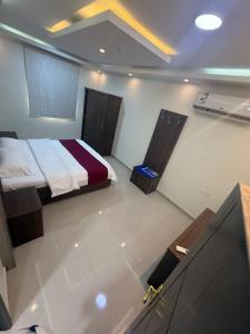 a bedroom with a bed in a room at ثار بارك للشقق المخدومة in Qushayya