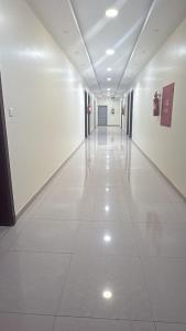 an empty hallway in a building with white floors and ceilings at ثار بارك للشقق المخدومة in Qushayya +1 photo