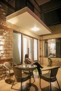 a woman sitting on a table in a living room at HOGS Panorama - Manali in Manāli