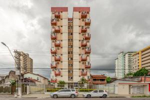a tall building with cars parked in front of it at Apartamento Canto da Chaco | by Aquarela Stays in Belém