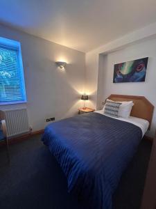 a bedroom with a large bed and a window at Castle Sleeper in Corby