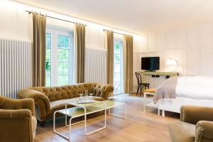 pokój hotelowy z łóżkiem, kanapą i stołem w obiekcie Das Kranzbach w mieście Krün
