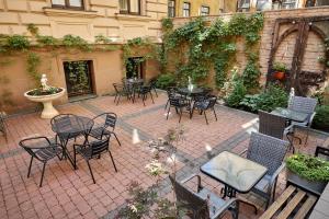 an outdoor patio with tables and chairs and a courtyard at Stabu Sēta Residence in Riga