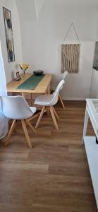 a dining room with a table and two white chairs at GOLD 3 in Sopron