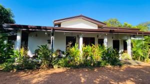 a white house with plants in front of it at Fairview Dill homestay in Sigiriya