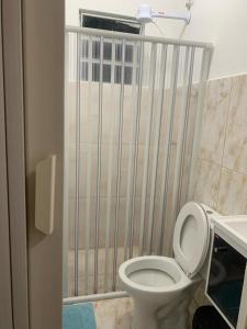 a bathroom with a toilet with a gate at POUSADA DAS NAÇÕES lll in Indaiatuba
