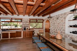 a kitchen with wooden ceilings and a stone wall at Magna in Dobropoljana