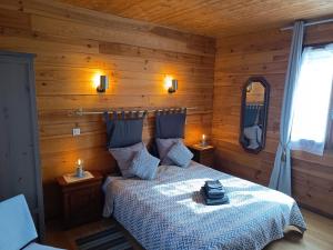 a bedroom with a bed in a wooden room at Domaine du Der - au milieu de nulle part, Chambres et tables dhotes au lac du Der in Outines