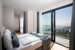 a bedroom with a bed and a large window at Carmen Residence Apartments in Opatija +289 photos